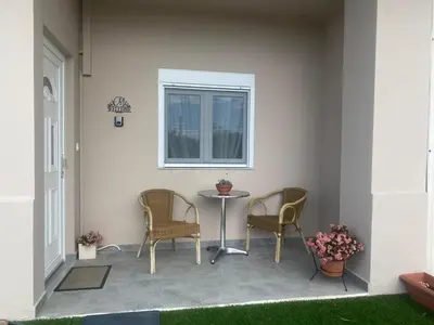 a patio with two chairs and a table and a window at MariAggela's Little House in Theologos