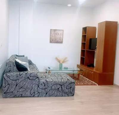 a living room with a bed and a table at MariAggela's Little House in Theologos