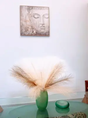 a vase with feathers in it sitting on a table at MariAggela's Little House in Theologos