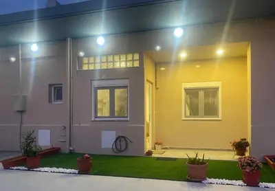a house with a yellow door and a yard with plants at MariAggela's Little House in Theologos
