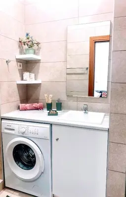 a bathroom with a washing machine and a sink at MariAggela's Little House in Theologos
