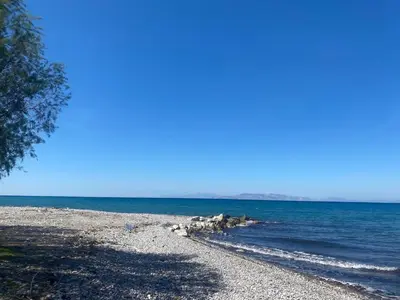 a rocky beach with the ocean on a sunny day at MariAggela's Little House in Theologos