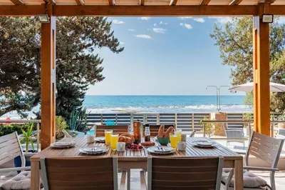 a wooden table on a patio with a view of the ocean at Villa Perla in Lardos