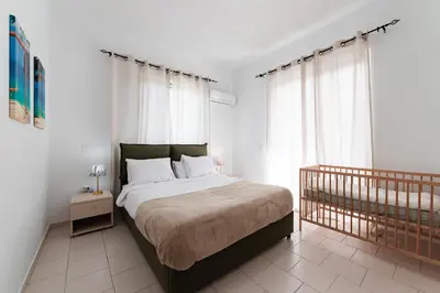 a bedroom with a large bed and a window at Villa Perla in Lardos