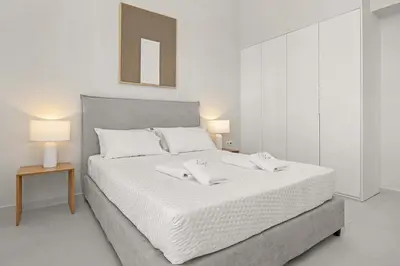 a bedroom with a white bed with two towels on it at Villa Petalutha Rhodes in Kolimbia