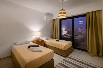 a hotel room with two beds and a window at Aquarama Pool Apt - Orion in Ixia