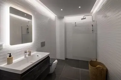 a bathroom with a sink and a toilet and a mirror at Aquarama Pool Apt - Orion in Ixia