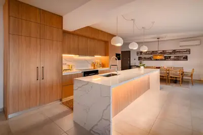 a kitchen with wooden cabinets and a kitchen island at Aquarama Pool Apt - Orion in Ixia