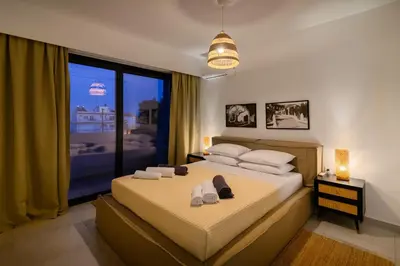 a bedroom with a bed and a large window at Aquarama Pool Apt - Orion in Ixia