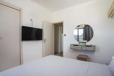 a white bedroom with a bed and a mirror at Rhodes Marina Apartment in Rhodes Town