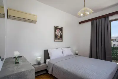 a bedroom with a bed and a window at Rhodes Marina Apartment in Rhodes Town