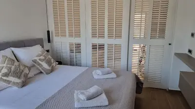a bedroom with a white bed with towels on it at Sulaj Apartments in Faliraki