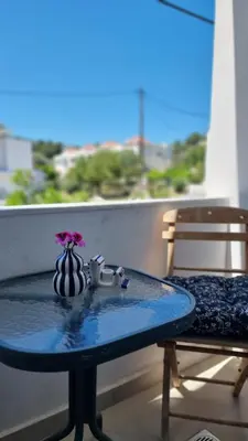 a blue table with a vase with a flower on a balcony at Sulaj Apartments in Faliraki