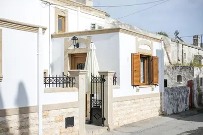 a white house with a black gate and an umbrella at Socrates traditional house in Haraki
