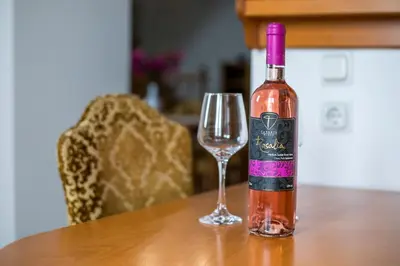 a bottle of wine sitting on a table next to a glass at Socrates traditional house in Haraki