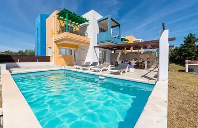 a villa with a swimming pool in front of a house at Lual Palette Rhodos in Afantou