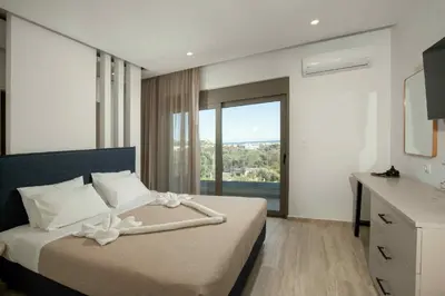 a bedroom with a bed with a large window at Villa Kennedy in Faliraki