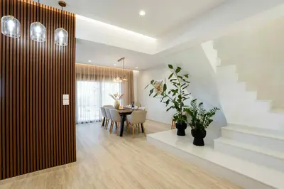 a living room with a dining room table and stairs at Villa Kennedy in Faliraki
