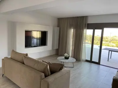a living room with a couch and a tv at Villa Kennedy in Faliraki