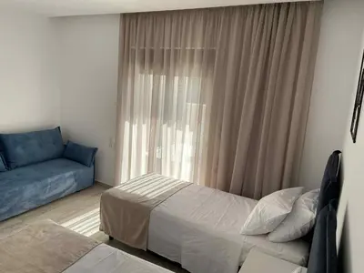 a bedroom with a bed and a couch and a window at Villa Kennedy in Faliraki