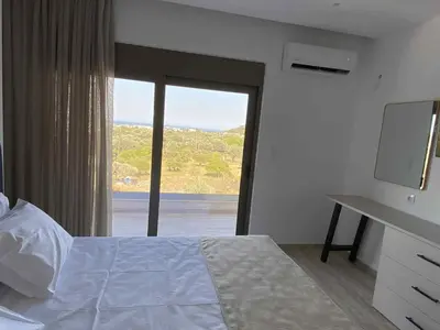 a bedroom with a bed and a large window at Villa Kennedy in Faliraki