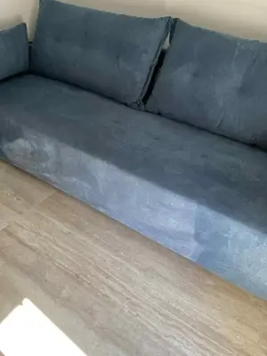 a blue couch sitting on top of a wooden floor at Villa Kennedy in Faliraki
