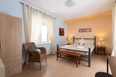 a bedroom with a bed and a chair and a table at Rhodes Garden Retreat in Rhodes Town