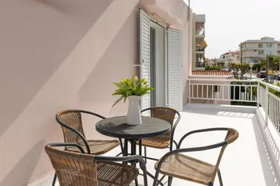 a table with chairs and a vase with flowers on a balcony at Rhodes Garden Retreat in Rhodes Town