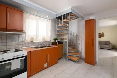 a kitchen with a spiral staircase in a room at Rhodes Garden Retreat in Rhodes Town