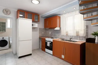 a kitchen with wooden cabinets and a white refrigerator at Rhodes Garden Retreat in Rhodes Town