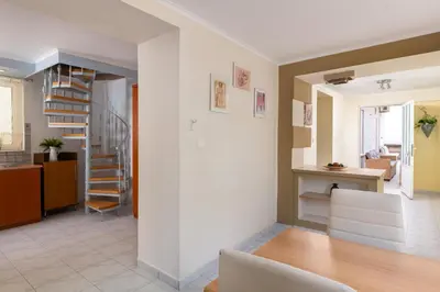 a living room with a staircase and a dining room at Rhodes Garden Retreat in Rhodes Town