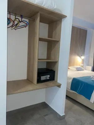 a room with a bed and a book shelf at OSIRIS HOTEL APARTMENTS and STUDIOS in Ialyssos