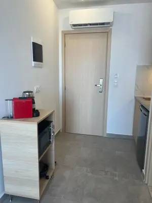 a room with a door and a kitchen with a counter at OSIRIS HOTEL APARTMENTS and STUDIOS in Ialyssos