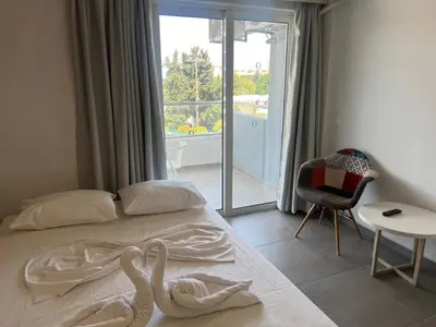 a bedroom with a bed with two swans on it at OSIRIS HOTEL APARTMENTS and STUDIOS in Ialyssos