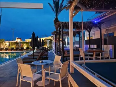 a hotel patio with tables and chairs and a pool at OSIRIS HOTEL APARTMENTS and STUDIOS in Ialyssos
