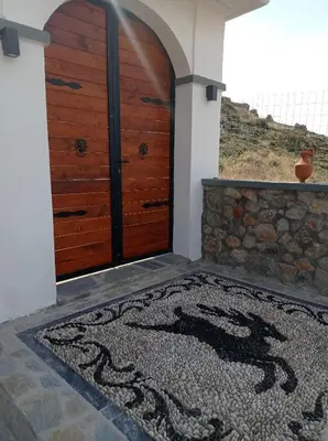 an entrance to a house with a door with a rug in front at Tassos Holiday home in Archangelos