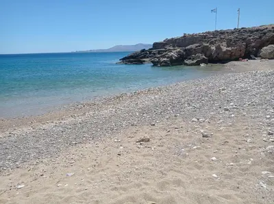 a beach with rocks and the ocean on a sunny day at Tassos Holiday home in Archangelos