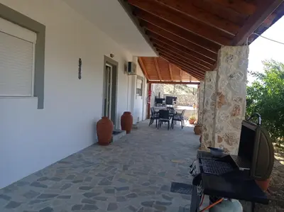 a porch of a house with a wooden roof at Tassos Holiday home in Archangelos