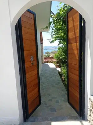 an entrance to a house with two wooden doors at Tassos Holiday home in Archangelos