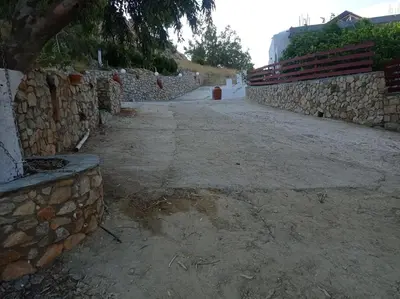 a stone wall next to a dirt road at Tassos Holiday home in Archangelos