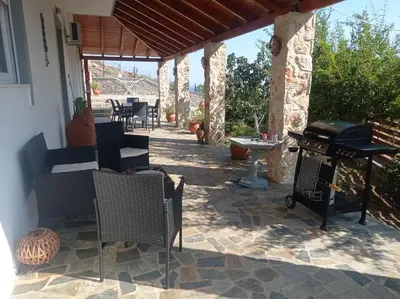 a patio with chairs and a grill on a house at Tassos Holiday home in Archangelos