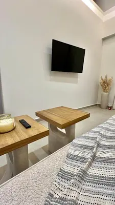 a living room with a table and a flat screen tv at Centro Blu Luxury Apartment in Rhodes Town