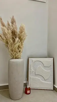 a vase with feathers in it next to a clock at Centro Blu Luxury Apartment in Rhodes Town