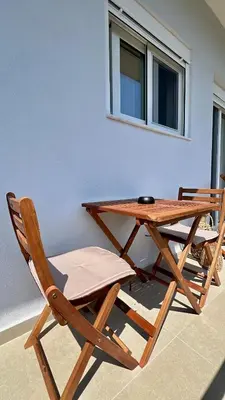 a picnic table and two chairs sitting next to a wall at Centro Blu Luxury Apartment in Rhodes Town