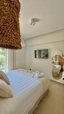 a bedroom with a large bed and a chair at Centro Blu Luxury Apartment in Rhodes Town