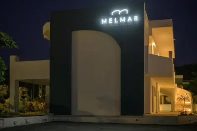 a building with a sign that reads melaan at night at MelMar Aegean Harmony in Faliraki