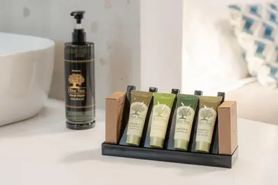 a box of four books on a table with a bottle of soap at MelMar Aegean Harmony in Faliraki