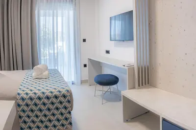 a room with a bed and a desk and a chair at MelMar Aegean Harmony in Faliraki