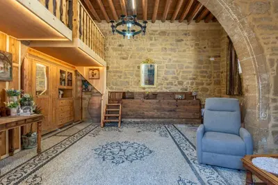 a living room with a blue chair and a staircase at Finieli's Rustico in Malona Village