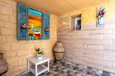 a room with a table and a window and a vase at Finieli's Rustico in Malona Village